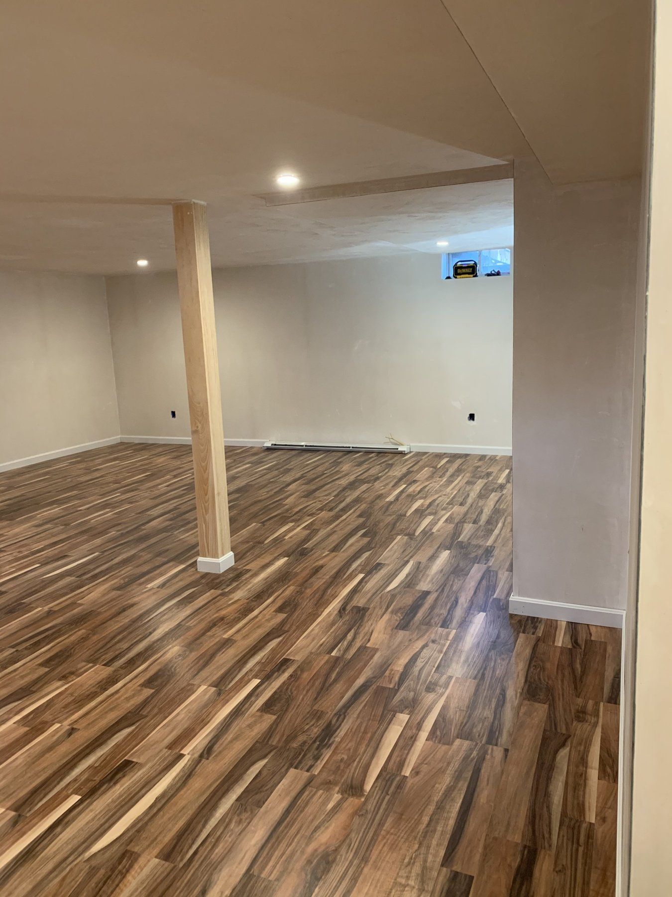 Finished basement with laminate floor and wrapped column