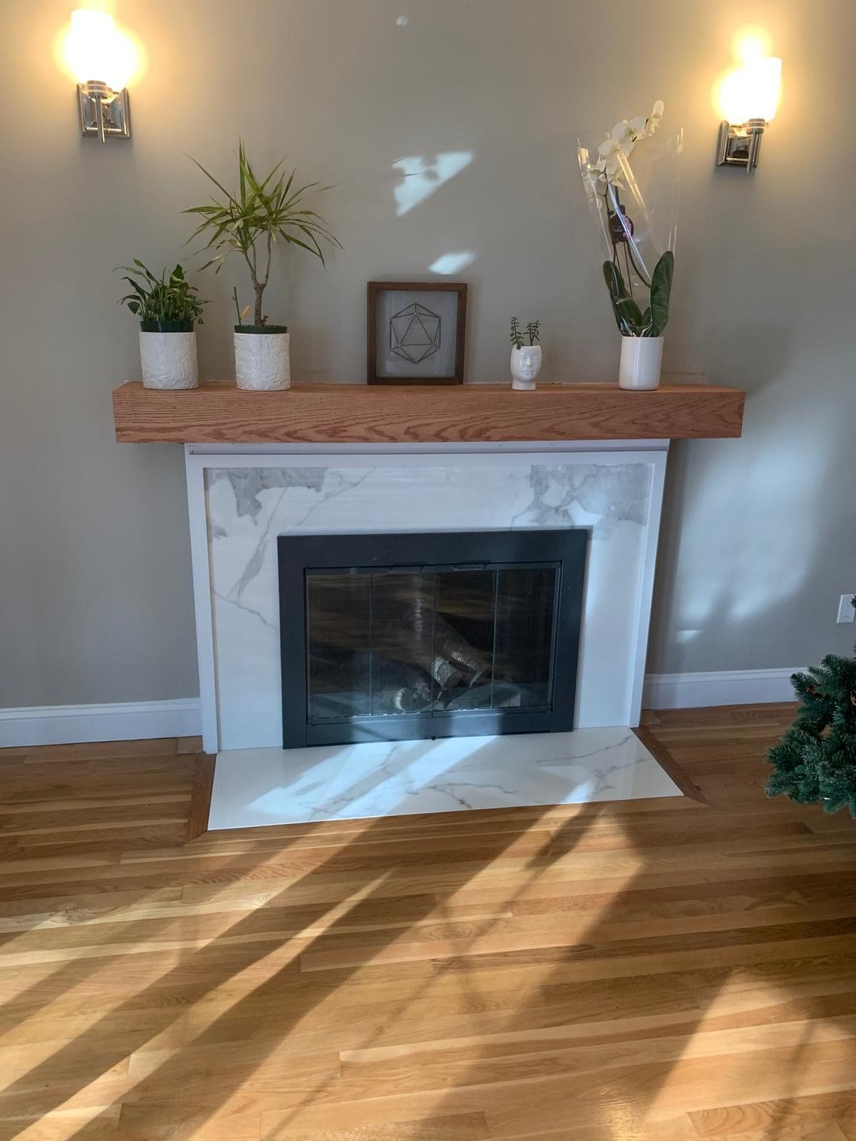Fireplace with marble-look tile surround and wood mantel