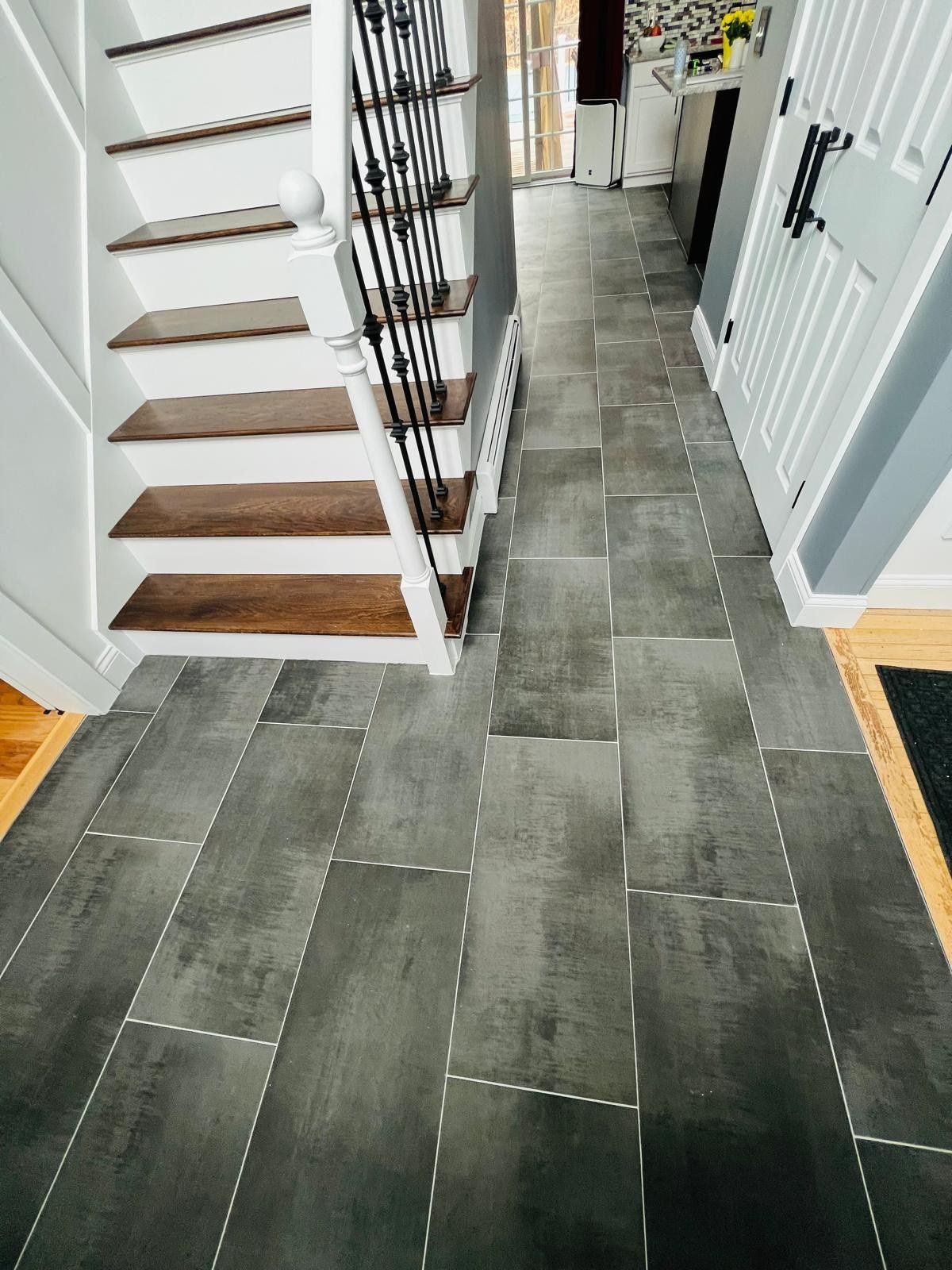 Gray porcelain tile hallway floor by the staircase