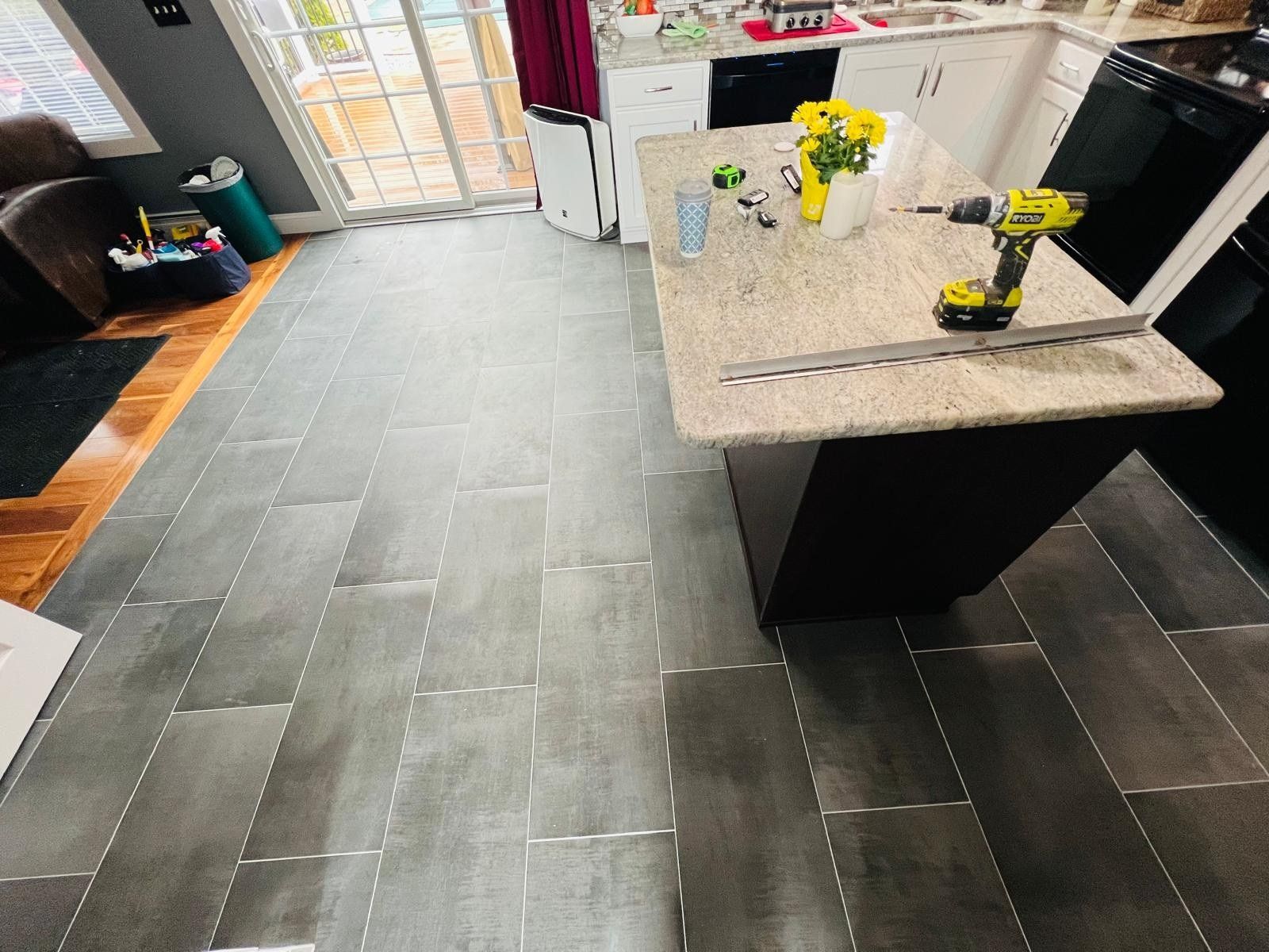 Gray tile kitchen floor around a granite island