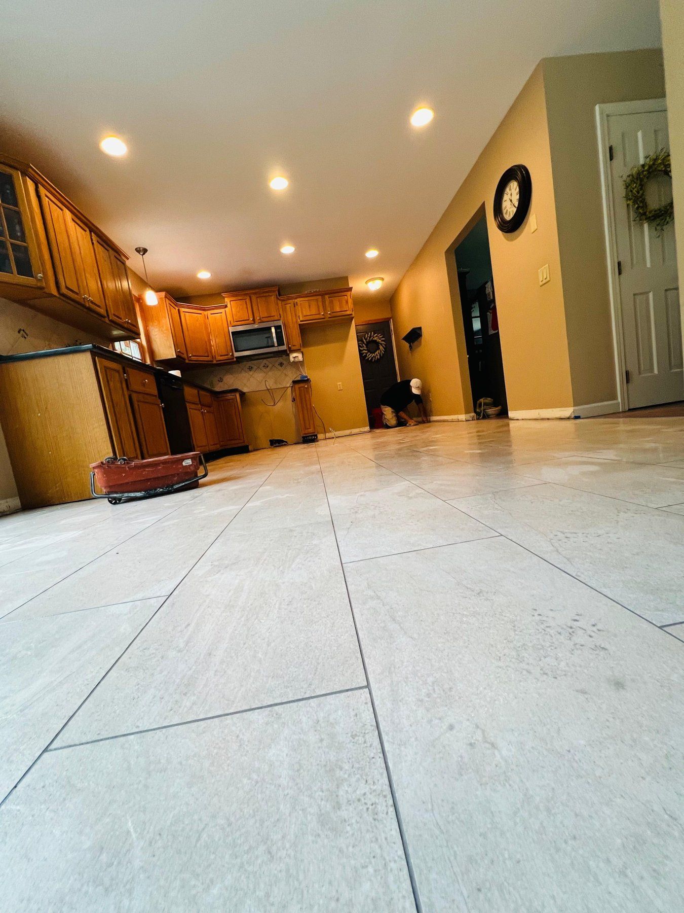 Large-format light porcelain tile floor in an open kitchen
