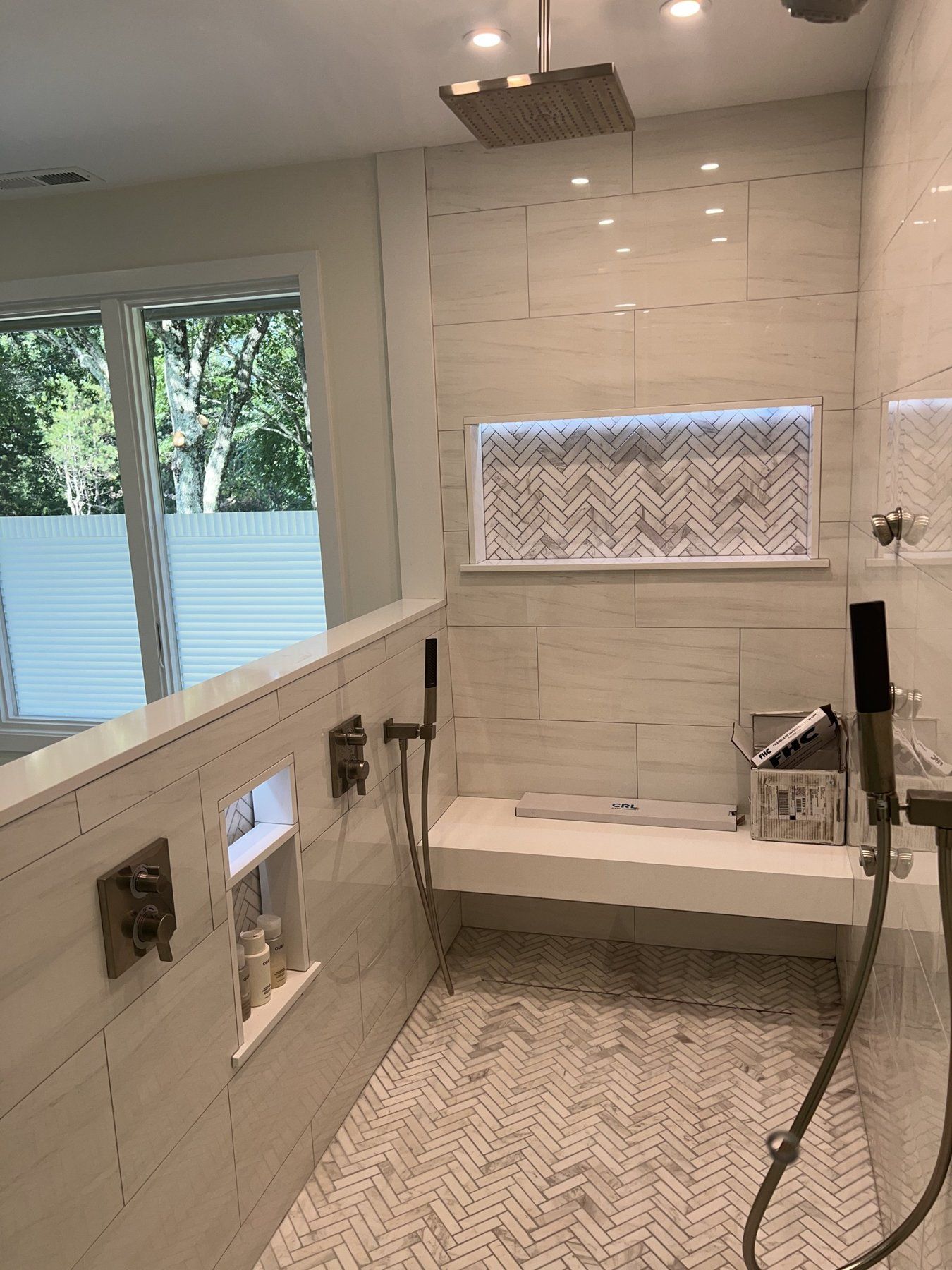 Walk-in shower with herringbone tile niche, built-in bench and rain head, bathroom remodel in Marlborough, MA