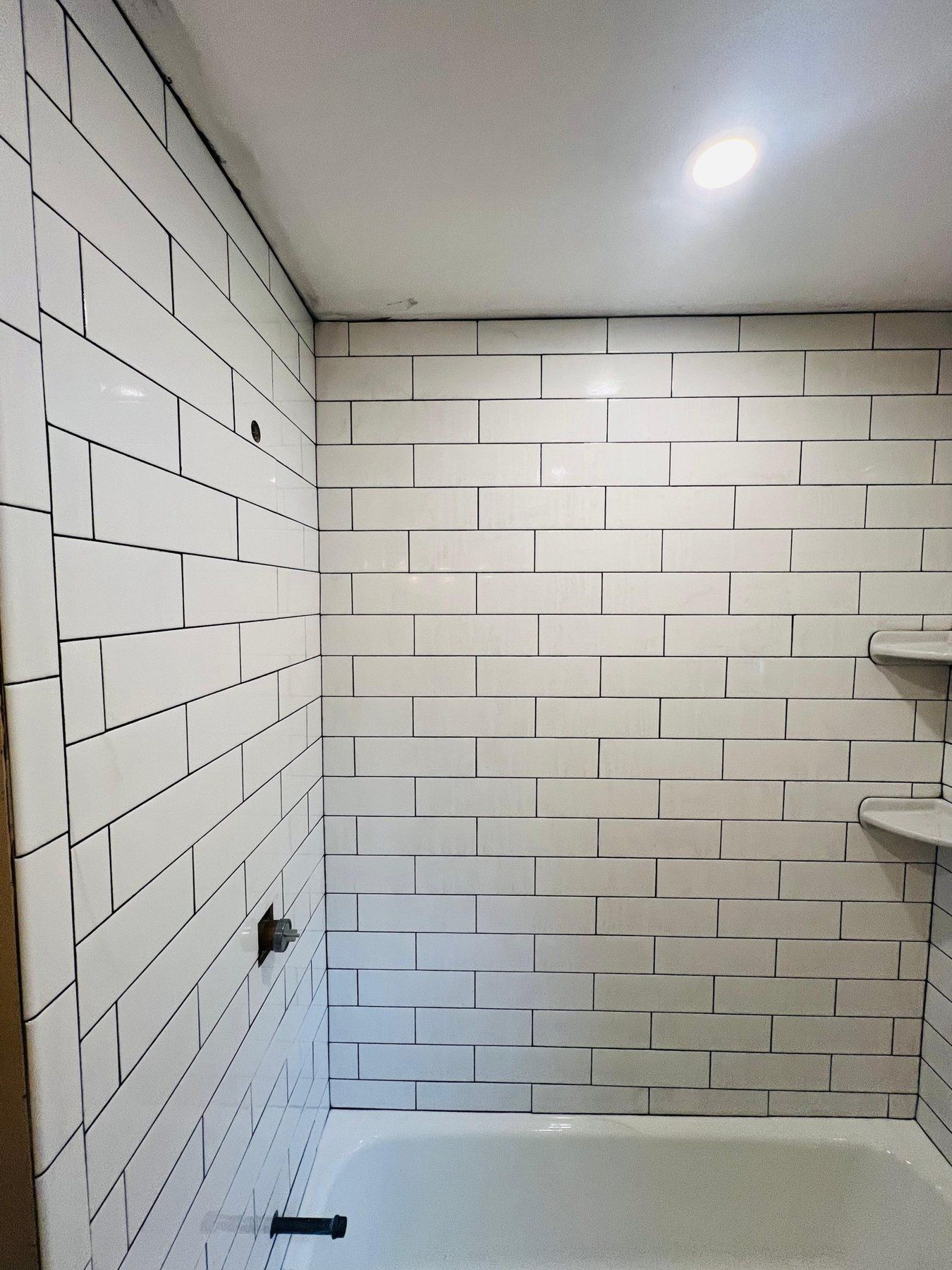 Classic white subway tile tub surround with corner shelves